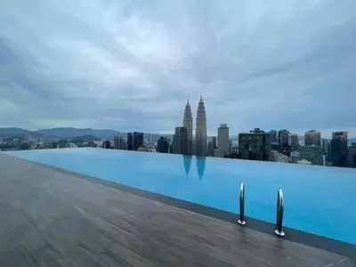 a swimming pool on the roof of a building with a city at The suits klcc in Kuala Lumpur