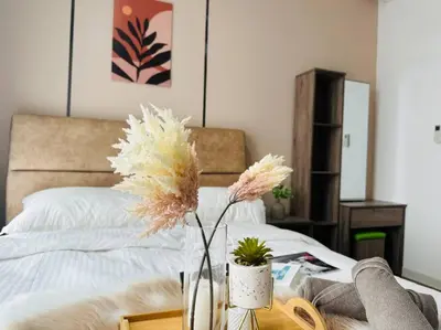 a vase with flowers on a table next to a bed at MVD41#Family Suite 8pax 3 Rooms M Vertica Velocity Mall Cheras IKEA Mytown Short Walk to MRT & LRT Maluri in Kuala Lumpur