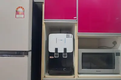 a white appliance in a cabinet next to a microwave at Fahrenheit 88, Bukit Bintang 10 in Kuala Lumpur