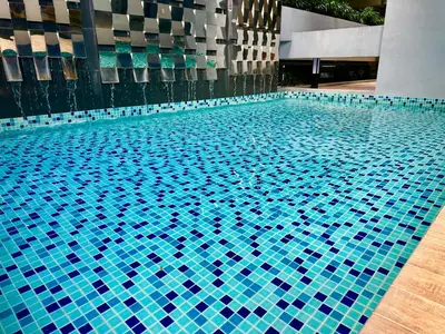 a blue tile swimming pool in a building at Neu Suites Service Apartment By Moonlight in Kuala Lumpur
