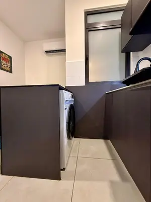 a kitchen with a washer and dryer in a room at Neu Suites Service Apartment By Moonlight in Kuala Lumpur