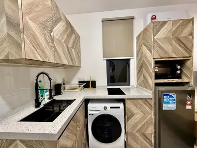 a small kitchen with a washer and dryer in it at Neu Suites Service Apartment By Moonlight in Kuala Lumpur