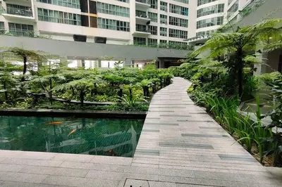 a walkway in a building with a pool of water at Immersed in the warmth and natural ambience in Kuala Lumpur