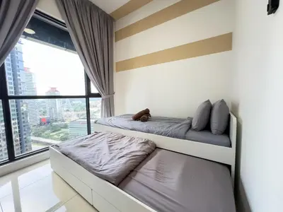 a bedroom with two beds and a large window at 5 pax - Bangsar South - 7 mins drive to Mid Valley in Kuala Lumpur