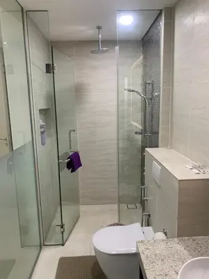 a bathroom with a glass shower and a toilet at Holiday Suites Star Residences in Kuala Lumpur
