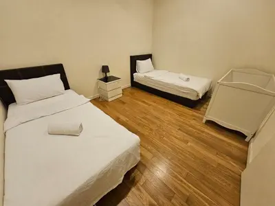 two beds in a small room with wooden floors at City Vibe Oasis St Mary Pavilion KLCC 3Bed6pax in Kuala Lumpur