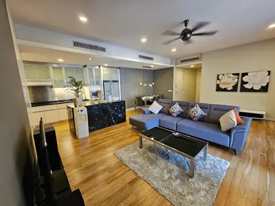 a living room with a blue couch and a kitchen at City Vibe Oasis St Mary Pavilion KLCC 3Bed6pax in Kuala Lumpur