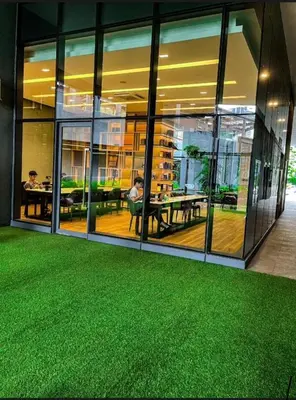 an office building with a green carpeted floor in front of windows at Star KLCC by homestay in Kuala Lumpur