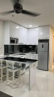 a kitchen with white cabinets and a table and a refrigerator at KL City Centre in Kuala Lumpur