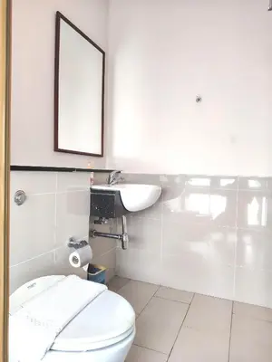 a bathroom with a toilet and a sink and a mirror at Swiss Garden Residence by Offex Suites KL in Kuala Lumpur