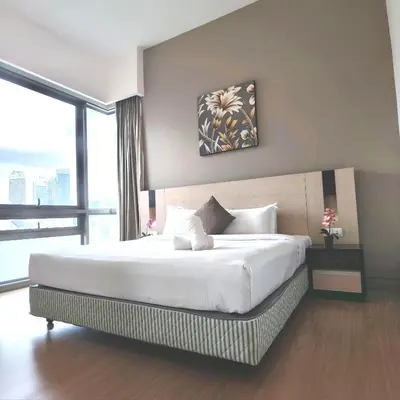 a bedroom with a large white bed with a large window at Swiss Garden Residence by Offex Suites KL in Kuala Lumpur