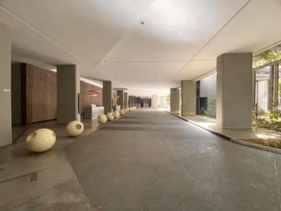 an empty hallway of a building with columns and windows at The Mews KLCC by PILLOWTALKS in Kuala Lumpur