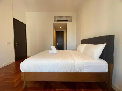 a bedroom with a large bed with white sheets at The Mews KLCC by PILLOWTALKS in Kuala Lumpur