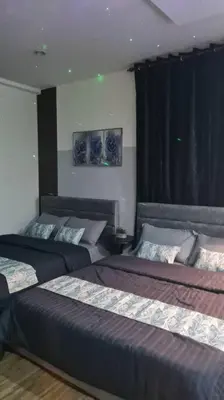a bedroom with two beds and a black curtain at Phenomenal atmosphere 4 PAX setapak central mall in Kuala Lumpur