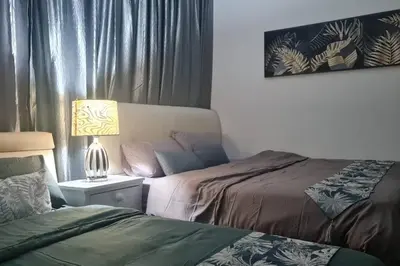 a bedroom with two beds and a lamp on a table at Cozy studio family lake view SETAPAK CENTRAL MALL in Kuala Lumpur