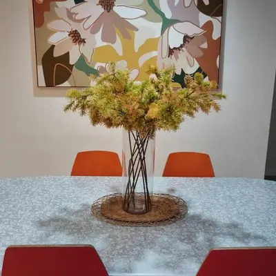 a vase of flowers on a table with two chairs at Cozy lake view at top of setapak central mall in Kuala Lumpur