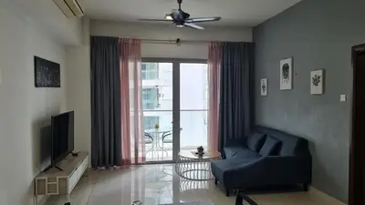 a living room with a blue chair and a television at Hostel At Regalia Residence in Kuala Lumpur