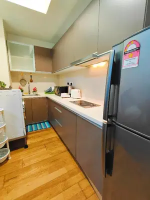 a kitchen with a stainless steel refrigerator and wooden floors at Casablanca Skypool Hostel in Kuala Lumpur