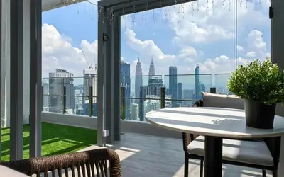 a balcony with a table and a view of the city at AGILE Bukit Bintang By Irent365 in Kuala Lumpur