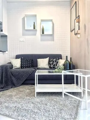 a living room with a blue couch and a glass table at Bmchomes Mercu summer suite in Kuala Lumpur