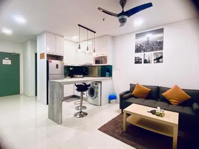 a living room with a couch and a kitchen at Bmchomes Mercu summer suite in Kuala Lumpur