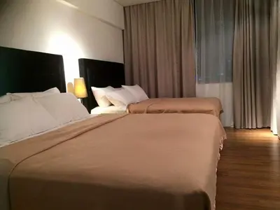 a hotel room with two beds and a window at Bmchomes Mercu summer suite in Kuala Lumpur