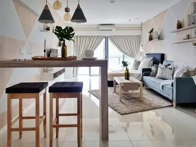 a living room with a blue couch and a table at Bmchomes Mercu summer suite in Kuala Lumpur