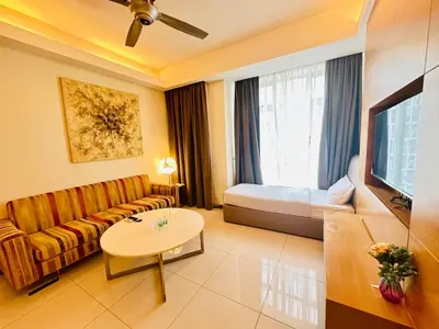 a living room with a couch and a bed and a tv at SOHO SUITES KLCC by DREAMS in Kuala Lumpur
