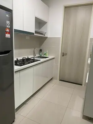 a kitchen with white cabinets and a stove and a door at Skyhomes KLCC New in Kuala Lumpur