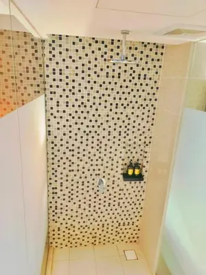 a bathroom with a shower with a tiled wall at Lila Suites D, Majestic Place in Kuala Lumpur