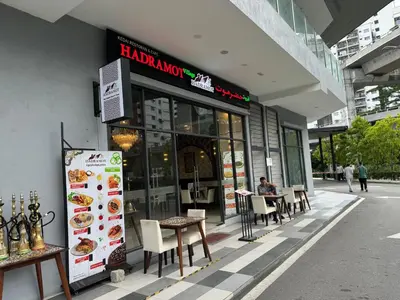 a person sitting at a table outside of a restaurant at KL City Nue Suites Entire Condo 2R2B 3 plus 1 guests in Kuala Lumpur