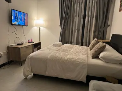 a hotel room with a bed and a television at KL City Nue Suites Entire Condo 2R2B 3 plus 1 guests in Kuala Lumpur