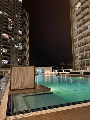 a large swimming pool at night with tall buildings at Casa Dbandar in Kuala Lumpur