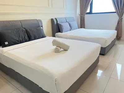 a room with two beds and a couch at Chambers Skylight Sernity Suites KLCC in Kuala Lumpur