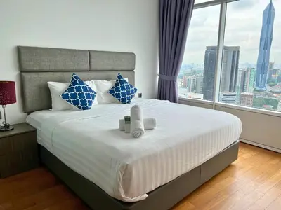 a bedroom with a large bed with a large window at Vortex Apartments Kuala Lumpur in Kuala Lumpur