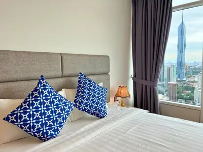 a bedroom with a bed with blue and white pillows at Vortex Apartments Kuala Lumpur in Kuala Lumpur