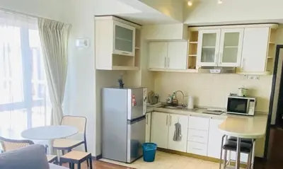a kitchen with a refrigerator and a table with chairs at Luxury Room At Bukit Bintang in Kuala Lumpur