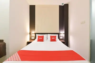 a bedroom with a bed with two red pillows at Hotel O Pollodium Chinatown in Kuala Lumpur