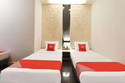 two beds in a room with red pillows at Hotel O Pollodium Chinatown in Kuala Lumpur