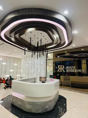 a lobby with a large chandelier in a building at Reizz Residence by Perkasa Suites in Batu Empat