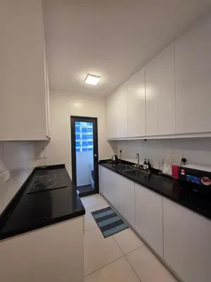 a kitchen with white cabinets and black counter tops at Reizz Residence by Perkasa Suites in Batu Empat