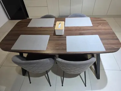 a wooden table with chairs and a phone on it at Reizz Residence by Perkasa Suites in Batu Empat