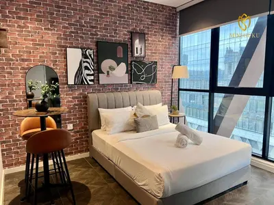 a bedroom with a bed and a brick wall at Scarletz Suites KLCC by Minshuku in Kuala Lumpur