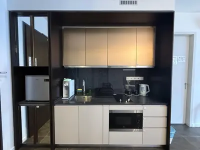 a kitchen with white cabinets and a microwave at Scarletz Suites KLCC by Minshuku in Kuala Lumpur