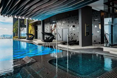 a swimming pool with blue water in a building at Scarletz Suites KLCC by Minshuku in Kuala Lumpur