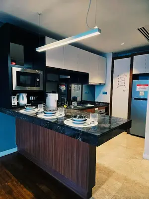 a kitchen with a counter with plates on it at Anggun Residence near KLCC Serviced Suite in Kuala Lumpur