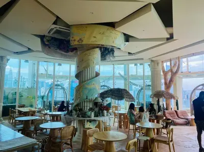 a restaurant with tables and people sitting at tables at Regalia KLCC View by Ucare Suites in Kuala Lumpur