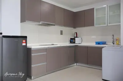a kitchen with brown cabinets and a refrigerator at Awesomestay Hostel near KLCC , walk to PWTC PUTRA in Kuala Lumpur