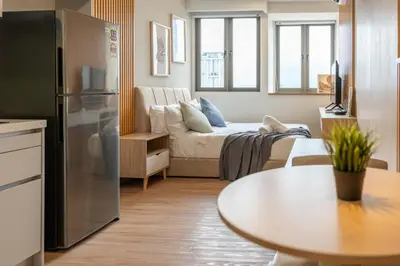 a kitchen and living room with a couch and a table at Riveria City at KL Sentral by Plush in Kuala Lumpur
