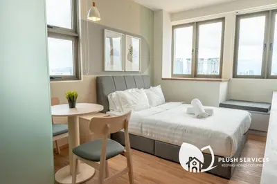 a bedroom with a bed and a table and a chair at Riveria City at KL Sentral by Plush in Kuala Lumpur